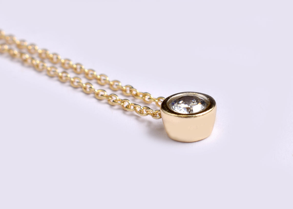 Elegant CZ solitaire pendant necklace with a sparkling round stone and delicate gold plated-tone chain. A timeless minimalist necklace for everyday wear