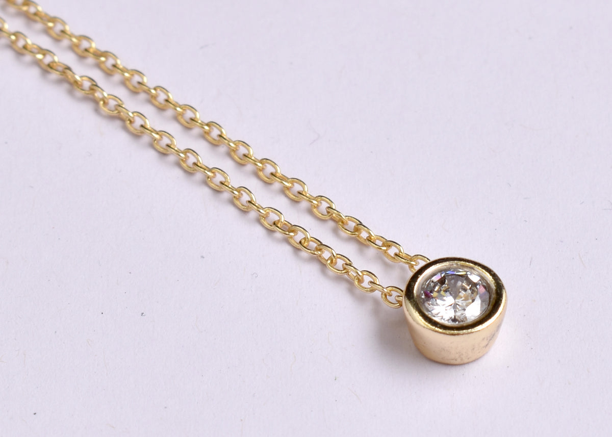Elegant CZ solitaire pendant necklace with a sparkling round stone and delicate gold plated-tone chain. A timeless minimalist necklace for everyday wear