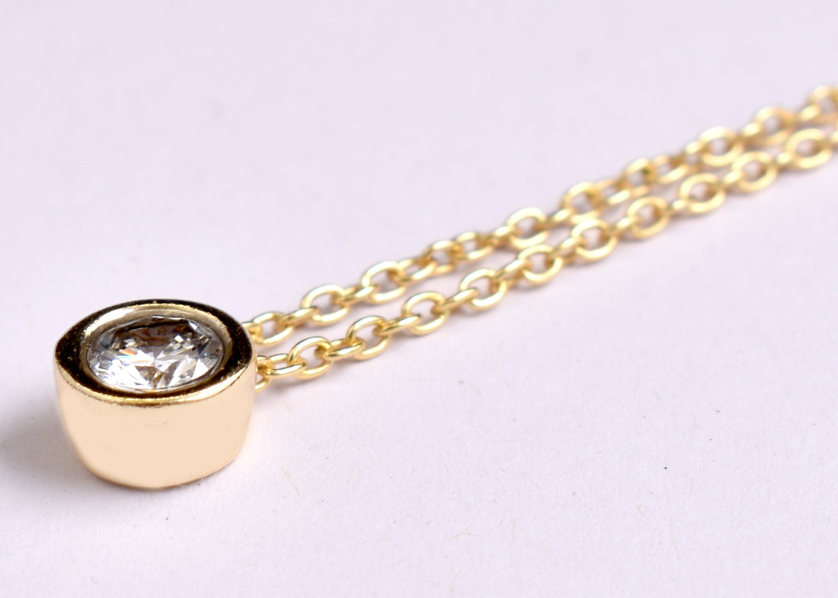 Elegant CZ solitaire pendant necklace with a sparkling round stone and delicate gold plated-tone chain. A timeless minimalist necklace for everyday wear
