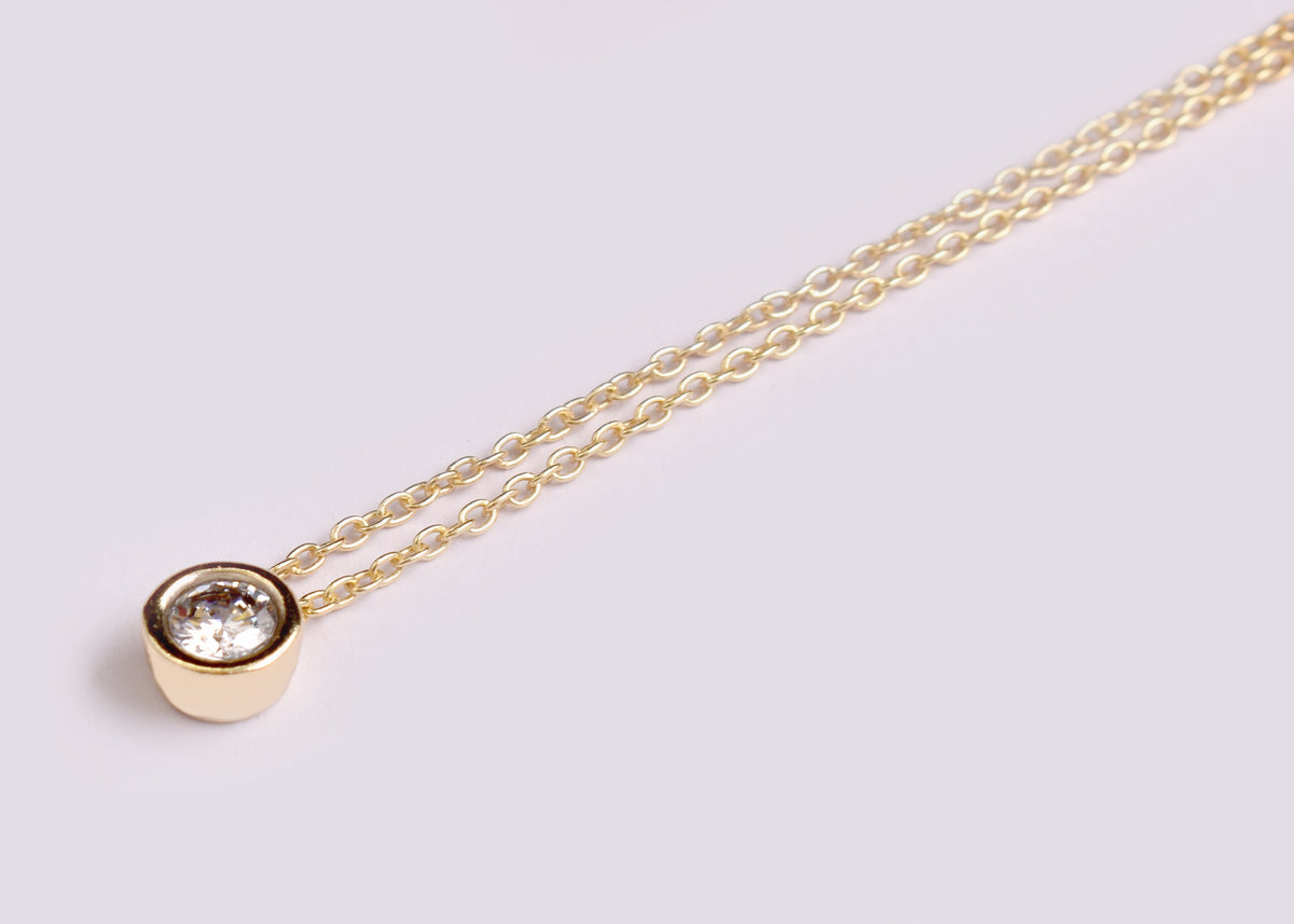 Elegant CZ solitaire pendant necklace with a sparkling round stone and delicate gold plated-tone chain. A timeless minimalist necklace for everyday wear