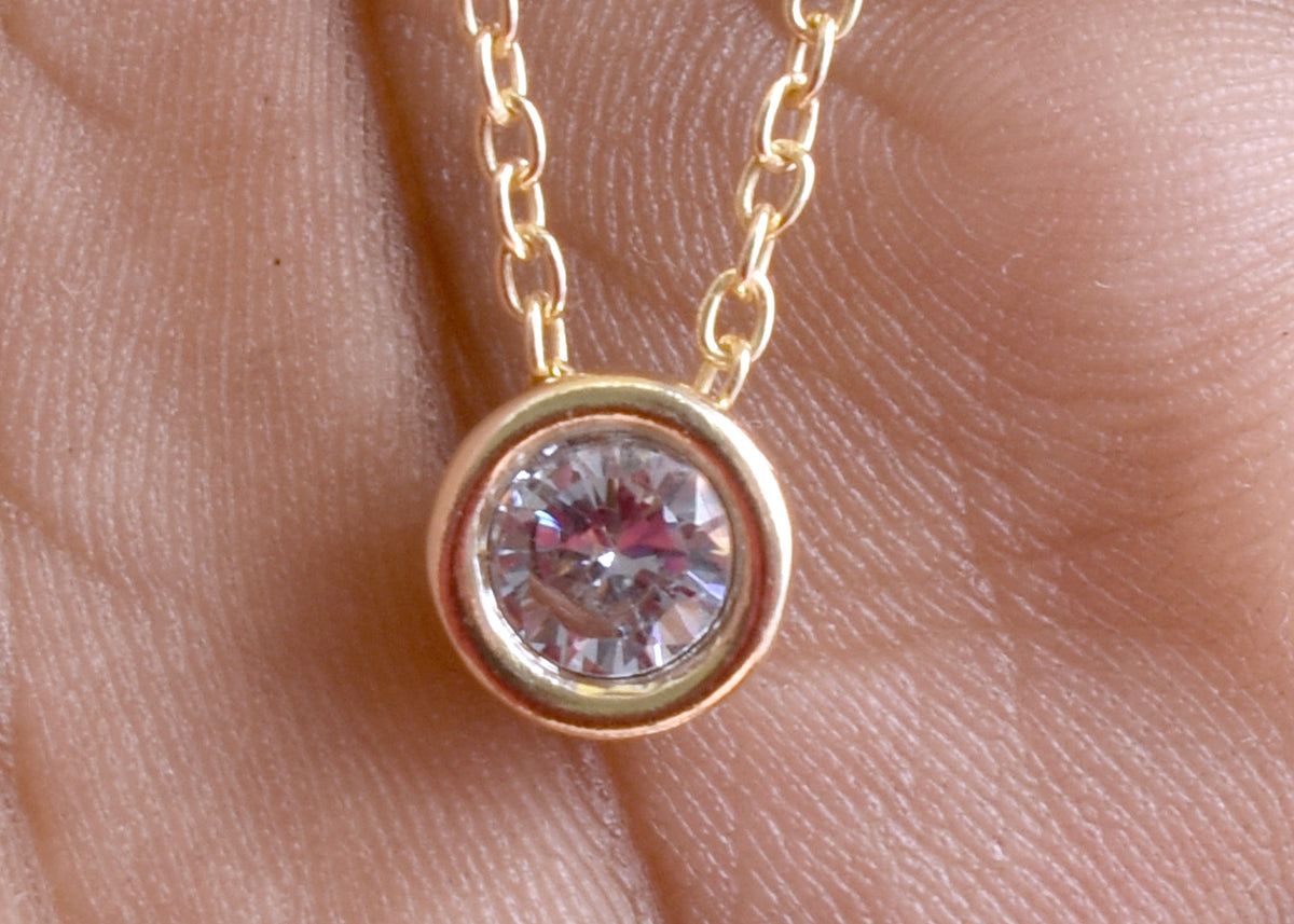Elegant CZ solitaire pendant necklace with a sparkling round stone and delicate gold plated-tone chain. A timeless minimalist necklace for everyday wear