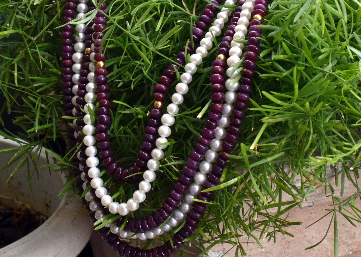 Elegant multi strand ruby and freshwater pearl necklace with gold accents. A luxurious statement piece for weddings, festive occasions and special events
