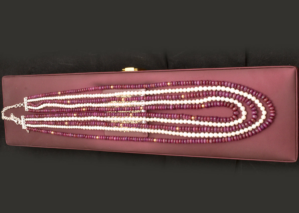 Elegant multi strand ruby and freshwater pearl necklace with gold accents. A luxurious statement piece for weddings, festive occasions and special events