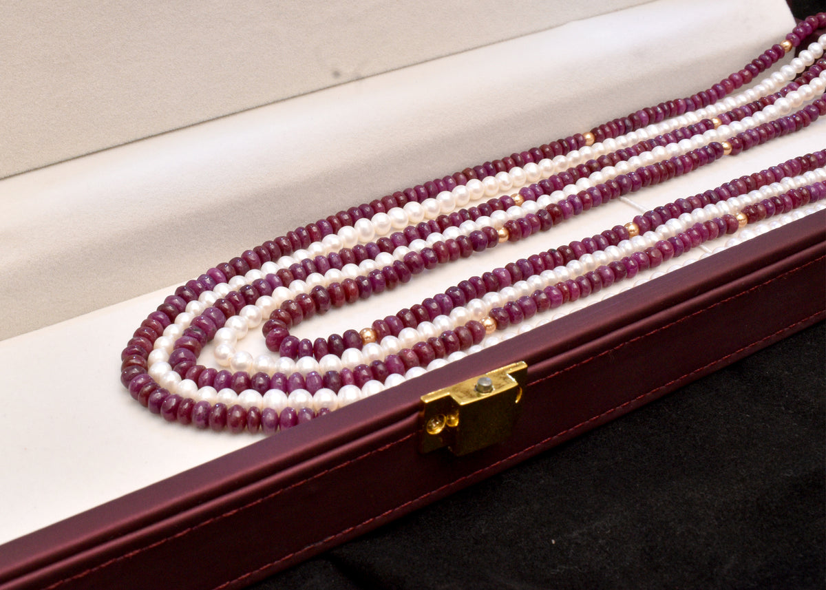Elegant multi strand ruby and freshwater pearl necklace with gold accents. A luxurious statement piece for weddings, festive occasions and special events
