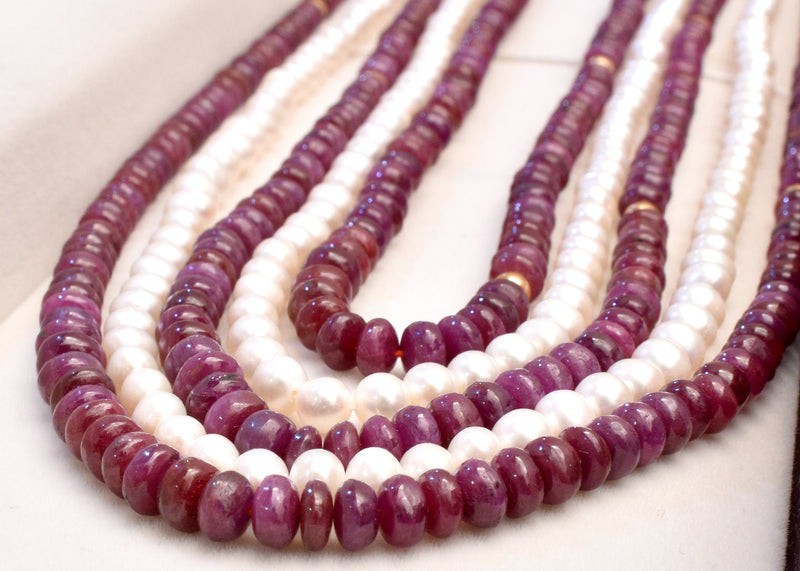 Elegant multi strand ruby and freshwater pearl necklace with gold accents. A luxurious statement piece for weddings, festive occasions and special events