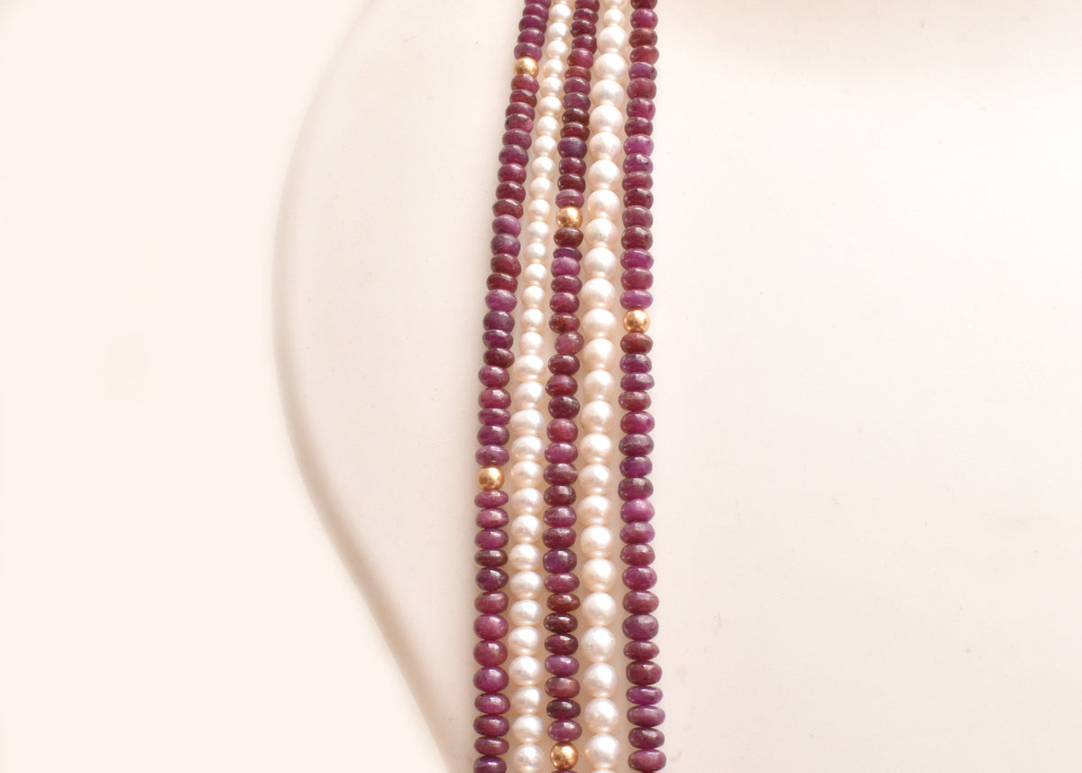 Elegant multi strand ruby and freshwater pearl necklace with gold accents. A luxurious statement piece for weddings, festive occasions and special events