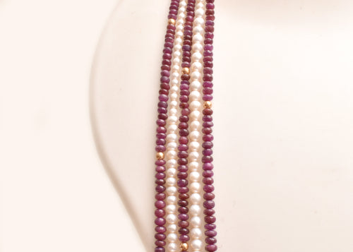 Elegant multi strand ruby and freshwater pearl necklace with gold accents. A luxurious statement piece for weddings, festive occasions and special events